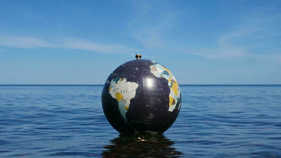 A fragile world adrift; where the fate of the planet floats between calm waters and an uncertain sky