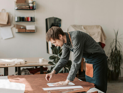 Artisan crafting leather goods in a workshop, showcasing heritage skills and precision