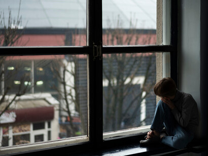 A child sitting isolated and motionless, reflecting the quiet grief of a boy who still waits to be found