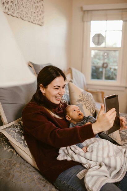 A mother holding her baby during a video call on a tablet—a tender moment of long-distance connection