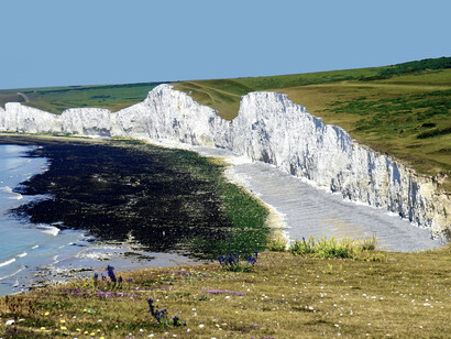 A rugged cliff rising above the shoreline in England, United Kingdom