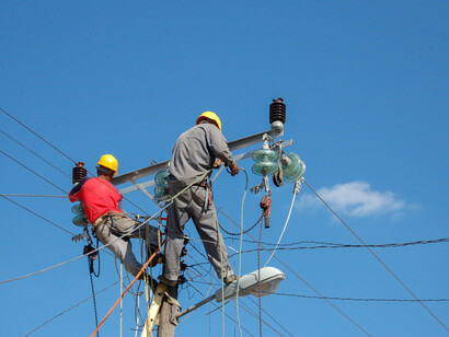 Operai elettricisti al lavoro su un palo