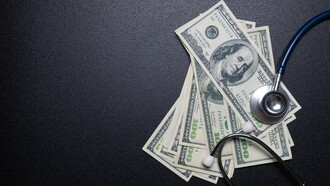 A stethoscope lying on currency bills, representing how the healthcare industry is often driven by profit and financial incentives rather than patient care