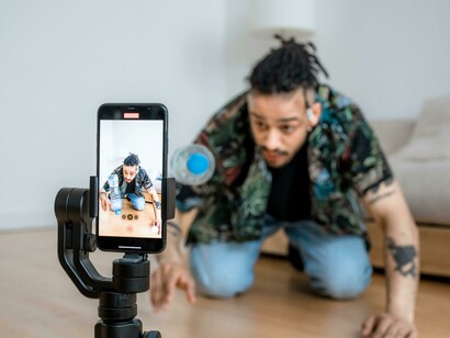 A man capturing content on his smartphone, representing the world of social media influencers and digital content creation