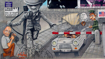 Berliner East-Side-Gallery. Graffiti: Volkspolizist Conrad Schumann springt über die Mauer