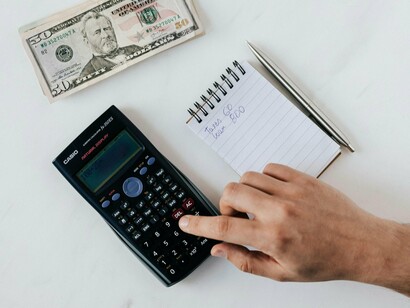 A person crunching numbers on a calculator, illustrating the quiet presence of politics in daily life