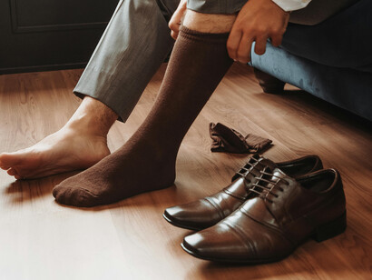 Stylish man lacing bespoke leather shoes, a symbol of tradition and lasting quality