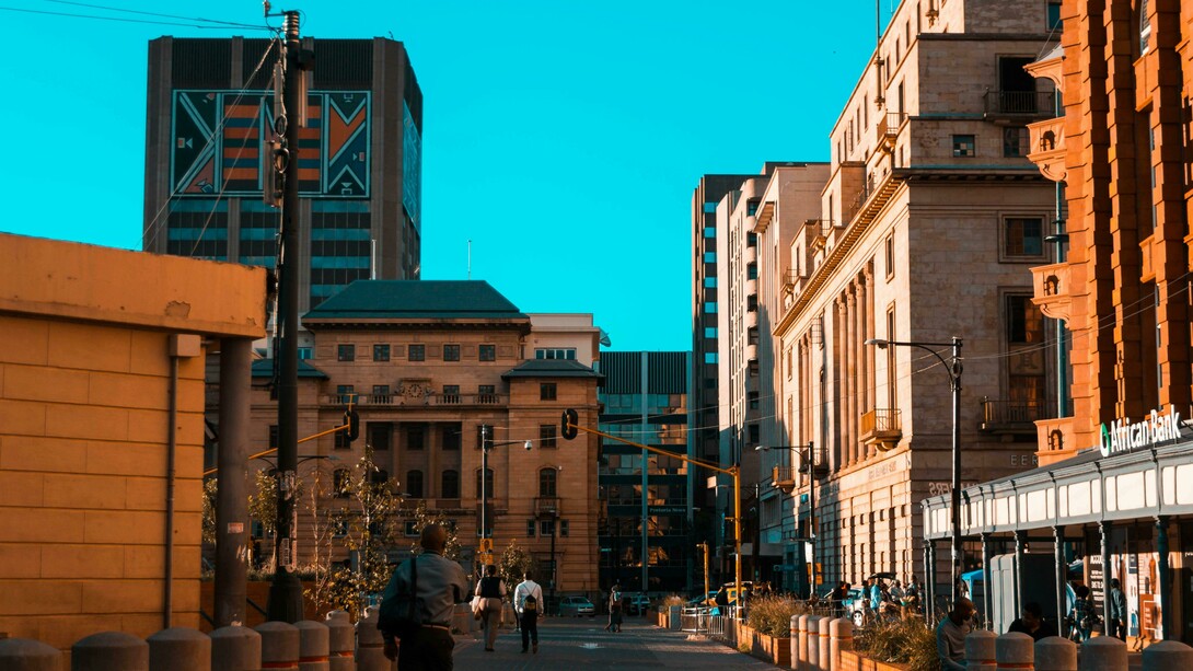 People stroll past modern buildings in the heart of Johannesburg, South Africa