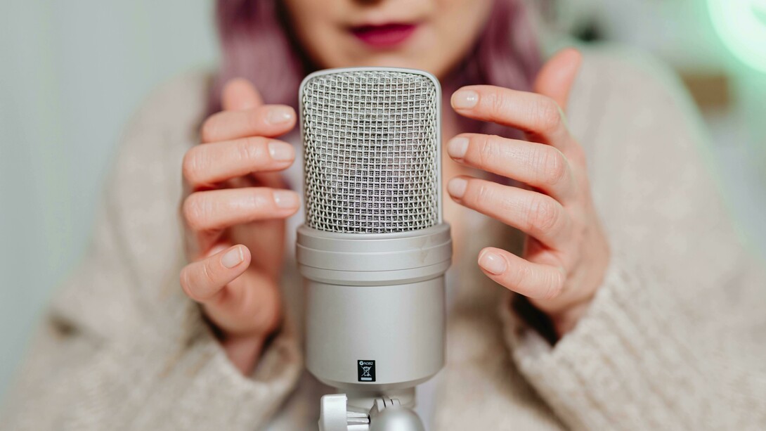 A woman placing her hand on a microphone