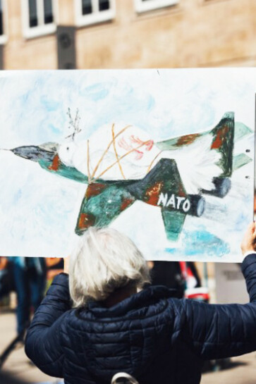 At the Easter March 2025 in Nuremberg, Germany — 'Never again war' — a protester held a drawing of an airplane labeled 'NATO'