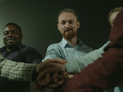 A diverse group embracing, with a man actively sharing—capturing themes of inclusion, connection, and belonging