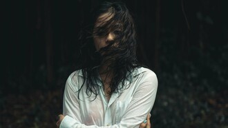 A woman drenched and looking drained, symbolising how some wounds take longer to heal and can pull you under the waves of grief at any moment