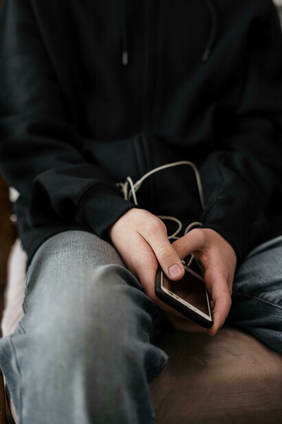 A lonely teenager in a black jacket and gray denim jeans, with visible scars on his hands—portraying the quiet struggles of teen anxiety, self-harm, and emotional isolation in a digitally saturated world