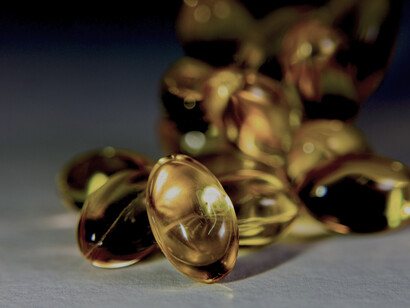 Close-up image of golden softgel capsules, commonly used for vitamins and supplements