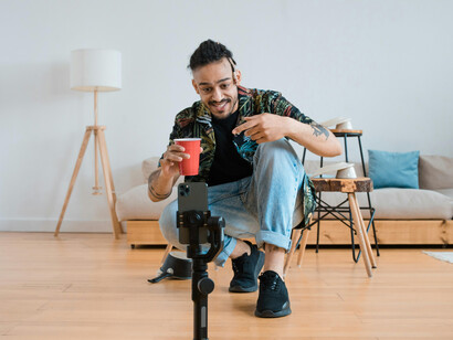A man recording himself with a smartphone, showcasing his role as a social media influencer and content creator