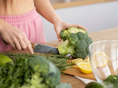 A young woman assembling a balanced diet with fresh broccoli, apples, and nutritious foods