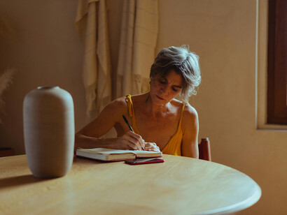 A woman journaling peacefully, honoring the stillness of personal transformation