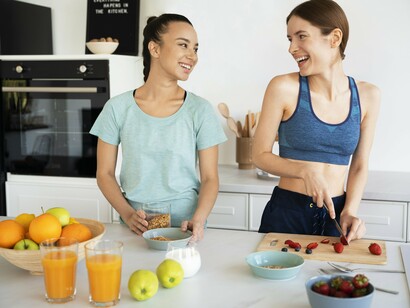 Chopping strawberries and pouring juice, the two friends embody the habit of eating close to the earth in good company