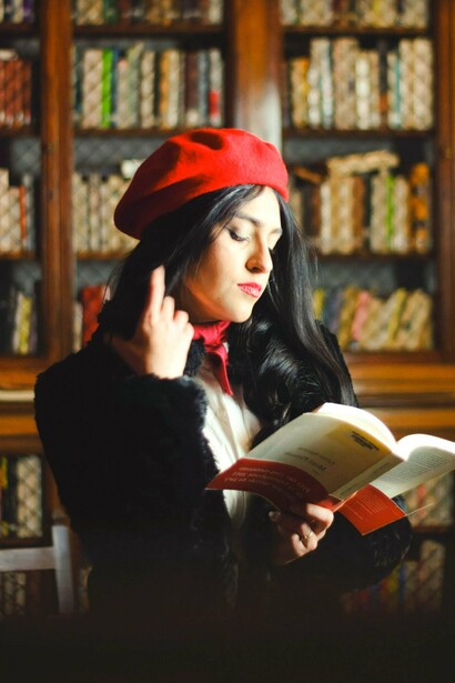 Mulher lê livro em biblioteca. Outro marco foi o surgimento das bibliotecas públicas, que democratizaram ainda mais o acesso à leitura. De repente, qualquer pessoa, independentemente de sua condição financeira, podia pegar um livro emprestado e mergulhar em um novo universo