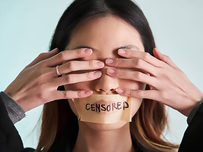 A woman’s mouth is sealed with plaster and tape, creating a powerful locked-mouth metaphor that reflects the suppression of freedom of expression during protest