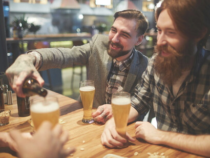Friends sitting at a bar, talking and laughing