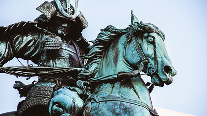 A statue of a man riding a horse, depicting a samurai in traditional Japanese armor