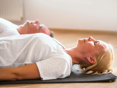Un uomo e una donna sdraiati durante una sessione di mindfulness