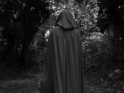 A faceless guardian in the trees—an image that captures the eerie mystique of those sworn to protect forbidden knowledge