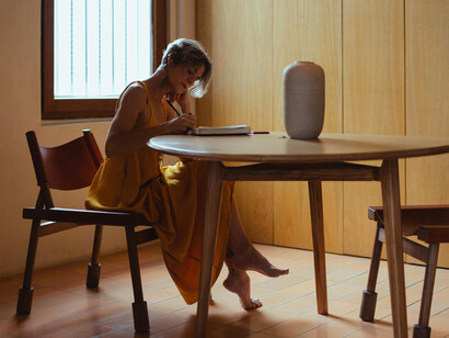 An elderly woman writing in quiet reflection, embodying self-care and inner alignment