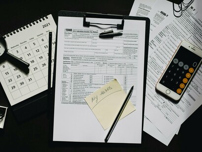 A spread of tax forms, a calculator, and a marked calendar hinting at financial accountability, representing how paper trails can expose misuse of public funds