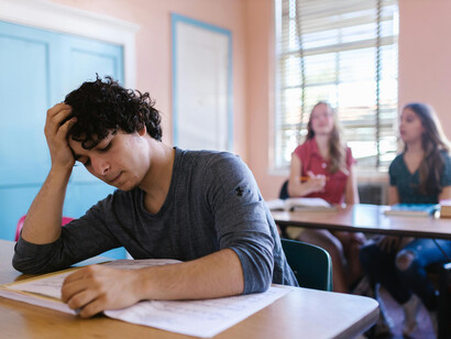 Two women are discussing a male student at school who seems isolated and withdrawn