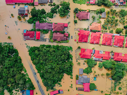 A neighbourhood swallowed by murky water, reflecting how substandard or ghost projects offered no protection when storms hit