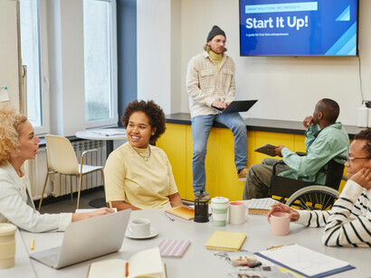 A man explains his ideas to the office team during a startup brainstorming session, as founders collaborate and prepare their pitch