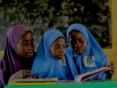 In a rural classroom, young girls in blue hijabs engage in learning—an inspiring image of education as a driver of development
