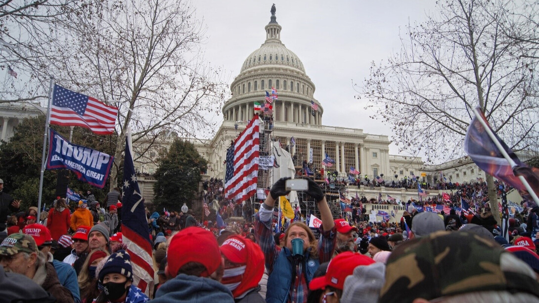 The storming of the USA Capitol on January 6, 2021. Rioters holding USA and “Make America Great Again” flags