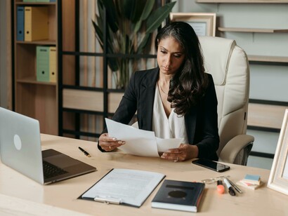 A woman working at her desk in an office, representing financial stability and career fulfillment