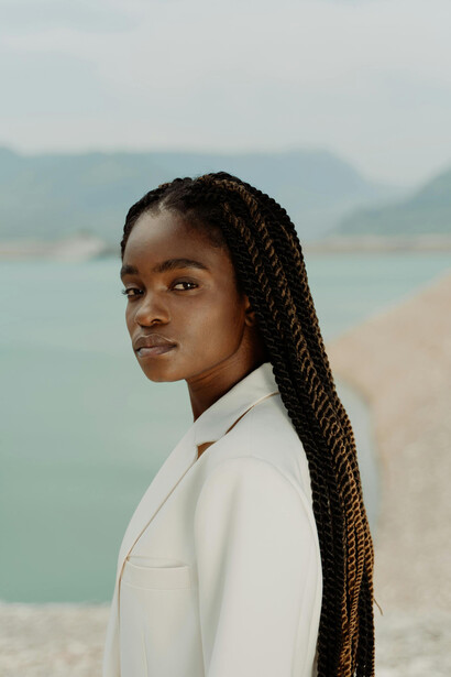 Stylish woman wearing a white suit and long box-braided hair
