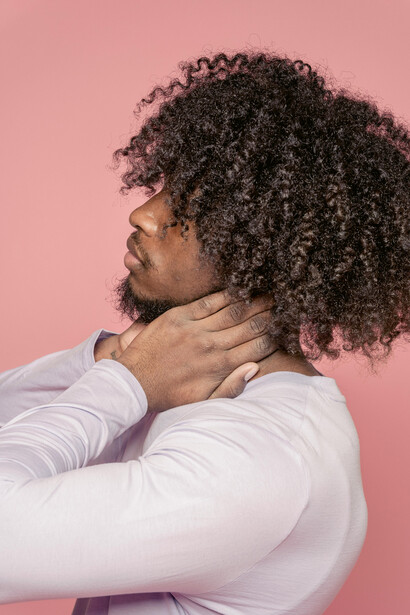 Serious Black man with long, natural Afro curls framing his face