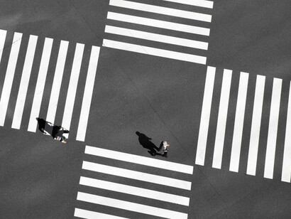 Silhouettes of people standing at a crossroads in a city