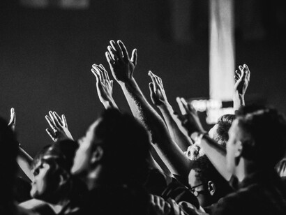 A group of people raising their hands in prayer and devotion