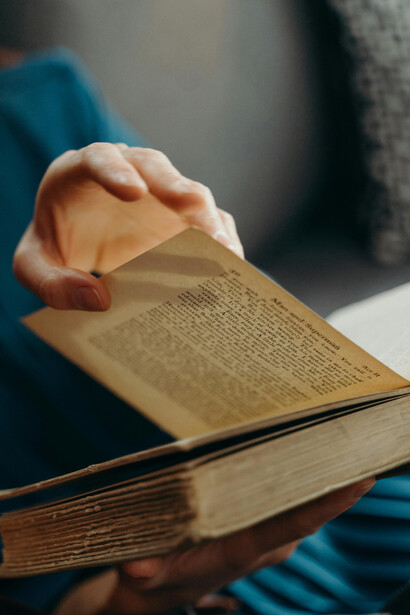 A close-up shot captures a person’s hands gently holding a book, evoking a sense of wisdom and lifelong learning