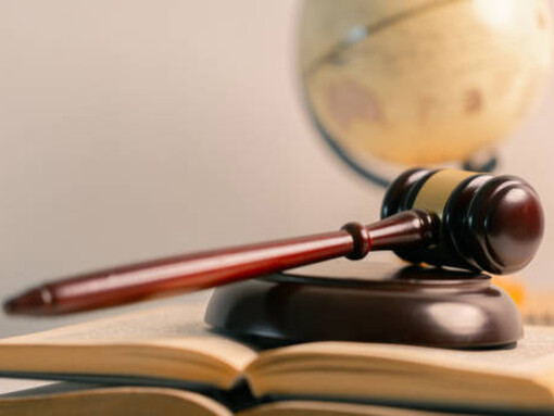 A representation of the legal system featuring law books, a courthouse theme, and a globe to signify international justice