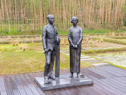 La diferencia filosófica clave con Occidente persiste: la acústica se separa de la forma mientras en China ritmo y volumen nacen de una misma lógica cósmica, visible en la horizontalidad de la Ciudad Prohibida frente a la verticalidad gótica europea. Estatuas de Lin Huiyin y Liang Sicheng  en Moon Field, Lizhuang