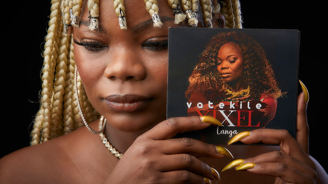 Um álbum surpreendente. Um disco solar, num país cinzento. Uma obra onde são percetíveis a dor de perder um pai, a dor de ser explorada e roubada, a dor da saudade, o amor à tradição, o sacrifício do trabalho para sustentar os (nossos) dependentes, abusando, num universo próprio, de elementos das mais diversas tipologias, como rock, jazz, bossa nova, psicadelismos, ambientalismo, africanismos, vários ou eletrónicas, sobretudo com uma descontração imensa e imersiva. É coisa rara por estes lados: um disco simultaneamente bem executado e capaz de respirar espontaneidade e graça por todos os poros