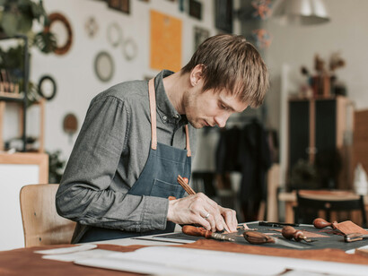 Skilled leatherworker in his studio, creating timeless pieces with classic tools