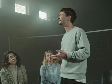 A man sharing in a group setting, highlighting community connection, family bonds, and a sense of belonging