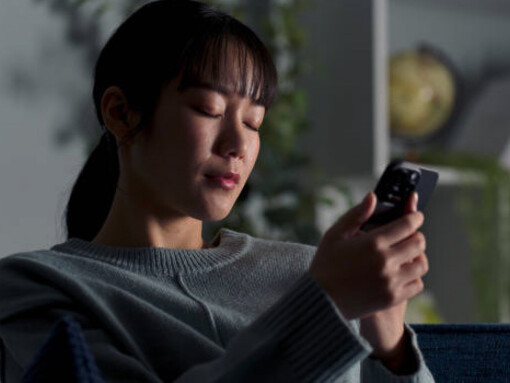 A woman feeling sad while browsing TikTok videos and Instagram Reels on her phone, caught in the grip of digital anxiety
