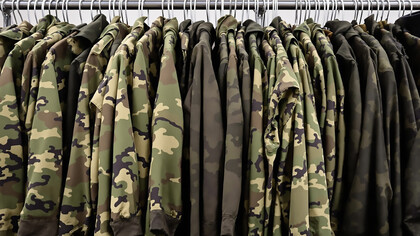 Military uniforms hanging on clothing rack