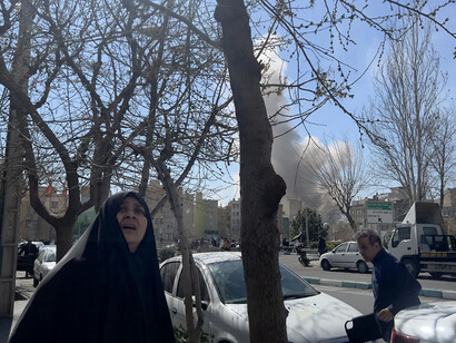 Missiles streak across the sky as smoke hangs over Tehran on the fourth day of war, Iran