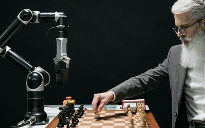 Un homme joue aux échecs avec une machine représentant une lutte entre l'intelligence humaine et l'intelligence artificielle